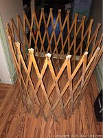 Top angle front view of the vintage solid wood expandable playpen showing the lattice structure and wooden knobs on the top edges.