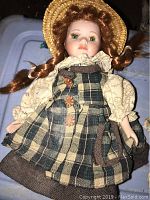 Annie Green Gables porcelain doll with braided red hair, plaid dress, and bonnet.