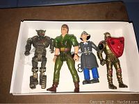 Four vintage action figures in a display box, showing overall lot contents and poses.