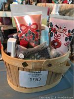Front view of Avon gift basket showing holiday-themed lotion tubes, various nail polish bottles, and other skincare and makeup items packed inside a wooden basket.