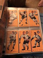 Photo showing a binder page with six hockey cards with beige backgrounds from Upper Deck 1997 set featuring various players.