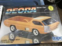 Box of Deora Show Car plastic model kit by MPC, front view showing an orange model car with wheels and clear window details.