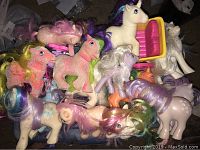 Pile of 15 vintage My Little Pony figures from 1980s, assorted colors and styles with pastel bodies and colorful manes/tails.