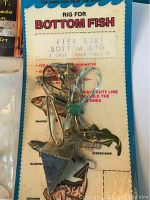 Photo of packaged Dragonfly bottom fish rig showing hooks, swivels, line, and printed illustrations of fish species and instructions.