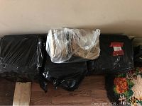 Five black plastic-wrapped boxes possibly containing LP records, shown stacked horizontally.
