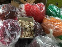 Various bags of star-shaped beads in colors red, green, orange, purple and small container of shell beads