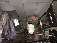 Top side view of Murray snowblower showing engine, chute, and controls with dirt and wear.