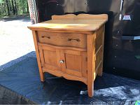 Full view of antique wooden washstand showing top, drawer, cabinet doors, and legs.