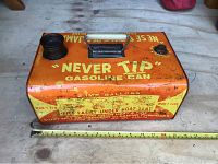 Top side and front view of the orange metal vintage gasoline can with yellow lettering "Never Tip Gasoline Can" and handle showing the spout and vent caps, with measuring tape for scale.