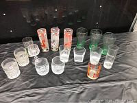 Front view of all 17 collectible glasses on a black surface showing arrangement and variety