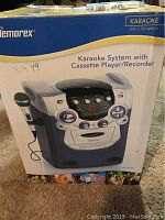 Photo of the boxed Memorex karaoke system packaging showing product image and model description