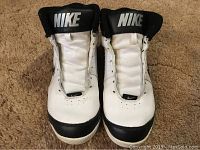 Front view of the pair of white and black Nike basketball shoes, size 10, with 'NIKE' label on the tongue and showing the upper front of the shoes.