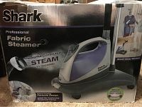 Box of Shark Professional Fabric Steamer with image of unit and claim of powerful continuous steam and bedbug and dust mite killing ability.