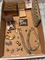 Lot overview showing gold-tone jewelry box, silver mesh bag, earrings, necklace and bracelet set, and assorted pins and jewelry.