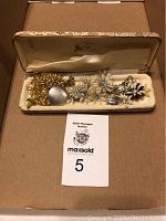 Open Coro jewelry box showing assorted vintage Coro earrings and brooch inside
