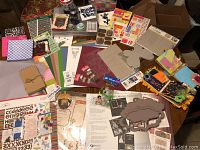 Full overview of scrapbooking materials including books, paper, chipboard, stickers, and other accessories spread out on floor.