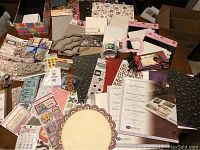 Wide angle photo showing all scrapbooking supplies laid out on a table including page protectors, papers, boxes, metal dies, stickers and embellishments