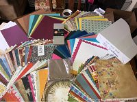 Photo of assorted scrapbooking papers and cardboard folder arranged on surface