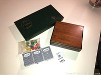 Overview of the lot showing the green Casino Rama card box, wooden box presumably containing poker chips, three decks of cards, and a bag of dice.