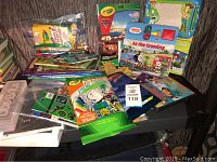 Table with kids activity books, coloring kits, baby moccasins, and various kids entertainment items mostly paper and craft supplies
