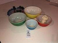 Overall view of four Pyrex mixing bowls and Pillsbury Doughboy figurine
