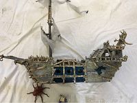 Top-down photo showing the full length of the skeleton pirate ship with visible mast, sails, windows, and rib-like skeletal structure.