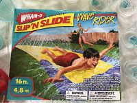 Box of Wham-O Slip N Slide Wave Rider showing children playing on the slide toy, unopened, 16 ft length