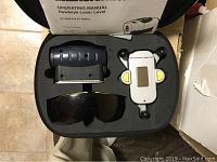 Top-down view of the laser level set including laser level device, glasses, detector and operating manual inside the carrying case