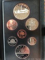 Coins arranged in black protective case; includes 1 dollar coin with Toronto skyline and Indian in canoe design, plus other Canadian coins in proof quality.