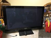 Front view of Panasonic 50 inch plasma TV on stand with remote placed in front.