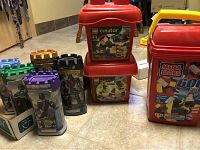 Another angle of two LEGO Creator bins stacked and Mega Bloks container, showing detail and condition of the containers and labels.
