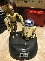 Front view of Star Wars C3PO and R2D2 coin bank on black base with logo visible.
