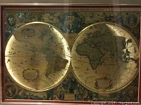 Close view of old world style double hemisphere map in frame with gold highlights