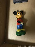 Vintage Mickey Mouse coin bank in standing pose with red shirt and blue pants