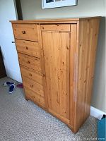 Full view of kids armoire showing six drawers and door on right side, made of pine wood with natural finish.