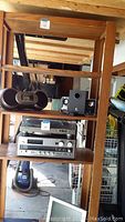 Full view of the wooden bookcase shelving filled with several electronic items (not included) to show scale and shelf construction.