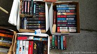 Boxed collection of fiction books showing multiple titles by Laurell K. Hamilton, others stacked inside boxes