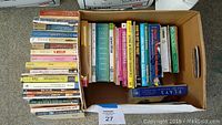 Box with assortment of plays and monologues, books stacked sideways and upright in box.