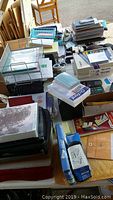 Wide view of assorted boxed and loose office supplies including paper pads, baskets, binders, and stamped files.