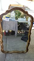 Large gold framed mirror with ornate detailing and classic curved top and sides, approximate size 26"x42.5".