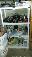 Four-tier white plastic shelving unit with kitchen items stored (items not included in sale).