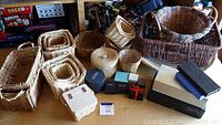 Various woven baskets and decorative boxes arranged together on a table.