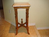 Full height view of the antique wooden lamp table with marble top showing turned legs and cross stretcher with central finial.