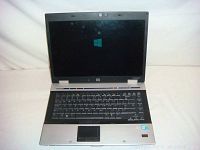HP EliteBook laptop powered on, showing Windows logo on screen.
