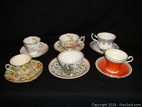 Front view of cups and saucers showing various floral and decorative patterns.