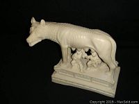 Front view of the vintage Romulus and Remus figurine showing the she-wolf and the twins Romulus and Remus nursing beneath her, mounted on a decorative base.