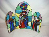 Frontal view of open stained glass triptych icon showing colorful religious figures