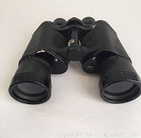 Front angled view of the vintage Selsi binoculars showing textured black body with visible wear and central focusing wheel.