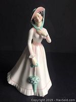 Frontal view of the Royal Doulton Julia figurine showing her face, bonnet, and parasol.