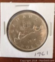 Front side of the 1961 Canadian silver dollar coin showing the stylized maple leaf and inscriptions including the year 1961.